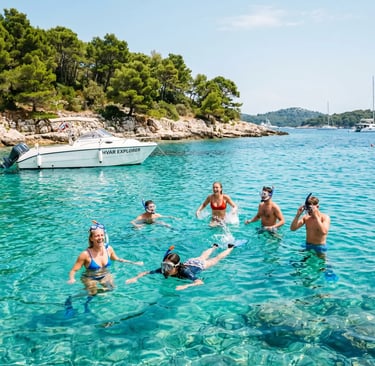 Group snorkeling in turquoise water near Hvar Explorer boat at Pakleni Islands, Croatia