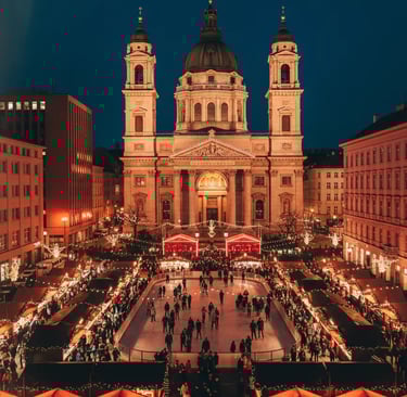 St. Stephen’s Basilica Christmas Market in Budapest at night, featuring glowing stalls, festive crow