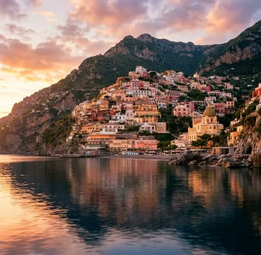Colorful Positano village cascading down cliffs reflected in calm sea at sunset