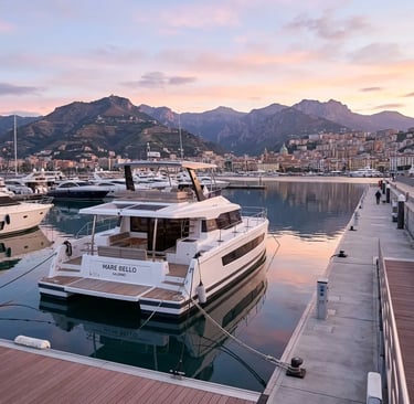 Luxury power catamaran docked at Marina d'Arechi Salerno with mountains at dawn