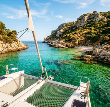Luxury catamaran anchored in a turquoise cove with limestone cliffs in Menorca