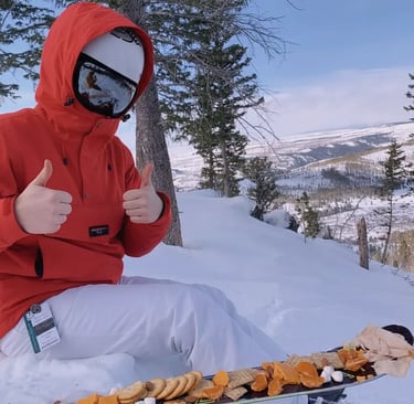 Close-up of clear containers filled with strawberries, blueberries, cubes of cheese, and prosciutto 