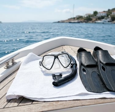 Snorkeling mask, snorkel, and fins on a white towel on a private boat deck near the coast