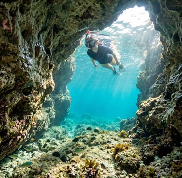 Woman snorkelling in clear turquoise water inside a Mediterranean sea cave in Salento, Puglia