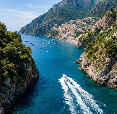 Aerial view of a private speedboat cruising between green cliffs toward Positano village