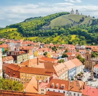 Sunny view of Mikulov main square with the historic clock tower and Holy Hill (Svaty Kopecek) South Moravia.