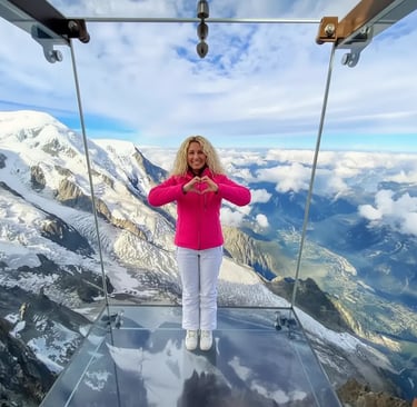 Woman making heart hands in Aiguille du Midi glass skywalk, Chamonix.
