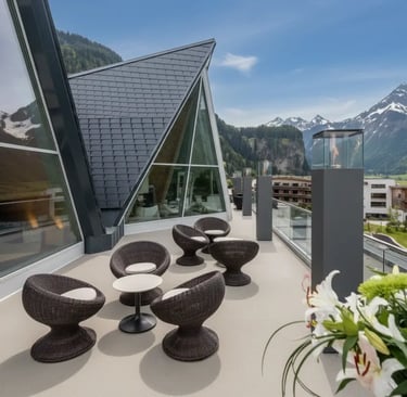 Modern outdoor lounge terrace at Aqua Dome with stylish dark wicker chairs and a view of the contemp