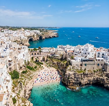 Aerial view of Polignano a Mare whitewashed cliffs and Lama Monachile beach with turquoise water