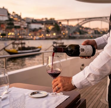 Sommelier pouring Quinta do Vale Meão red wine on a luxury yacht in Porto
