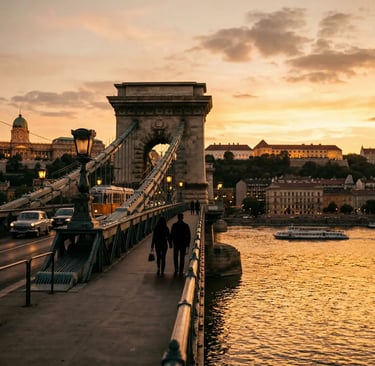 Couple silhouetted walking Chain Bridge at golden hour with Buda Castle in background