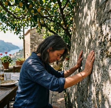 Traveler pressing hands against ancient stone wall at Luna d'Agerola farmhouse under lemon trees