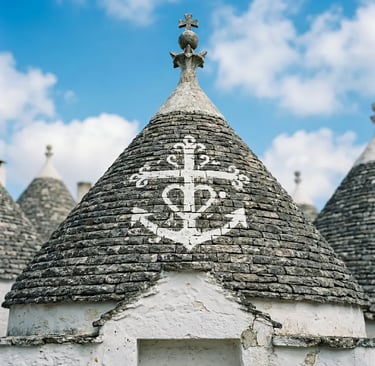Close-up of Alberobello trullo conical rooftop with white symbolic markings and pinnacle
