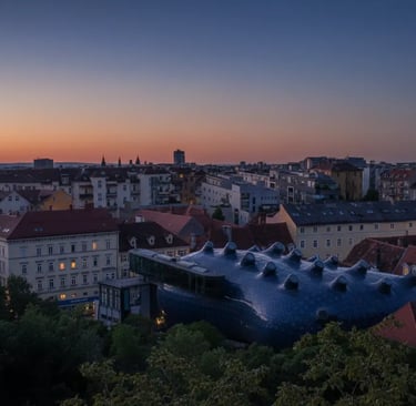 Aerial twilight view of Graz Austria with Kunsthaus roof glowing at sunset