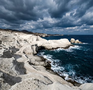 White volcanic rock formations of Sarakiniko beach in Milos with dramatic clouds and deep blue sea