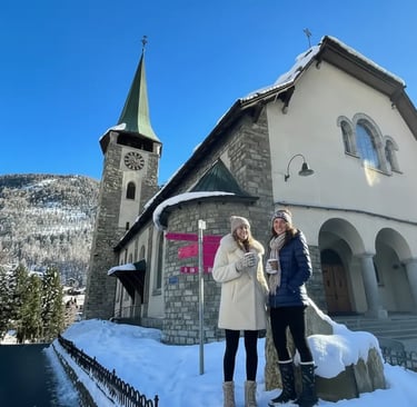 Travelers exploring the snowy Zermatt village center, standing in front of the historic St. Mauritiu