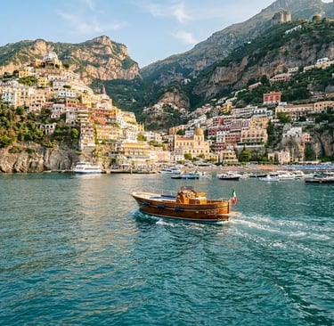 Wooden gozzo boat departing Positano harbor toward Capri, pastel cliffside town in morning light