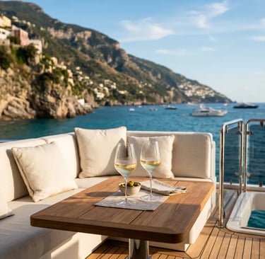 Two glasses of white wine and olives on yacht teak table along the Amalfi Coast