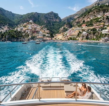 Couple on luxury yacht stern with Positano cliffside village and wake trail behind