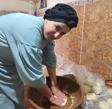 a woman in a blue shirt is holding a bowl of doughnuts