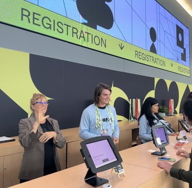 a sign language interpreter and a group of people at a registration booth for a conference