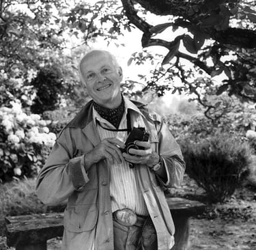 French photographer Henri Cartier-Bresson with his familiar Leica in a garden setting