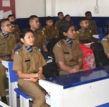 Girls in uniform sitting in a classroom at Sainik School, where doors open for females in Sainik Schools.  promoting female