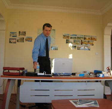 Jörg Grube steht hinter seinem ersten eigenen Schreibtisch