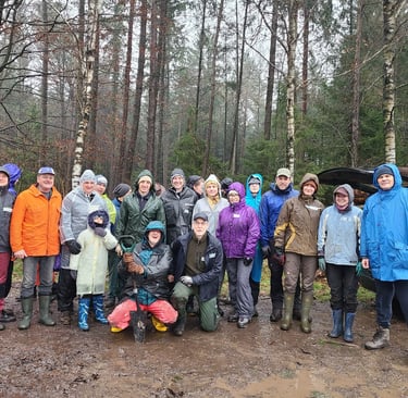 Jörg Grube mit einer Allwetterjacke in der Hocke vor einer Gruppe Männer