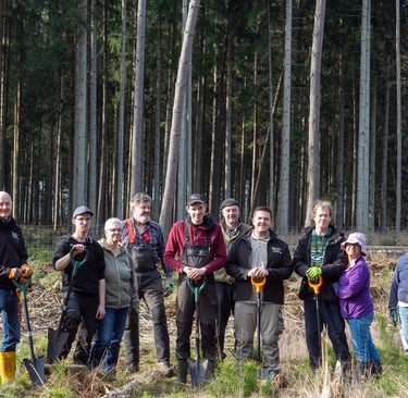 Jörg Grube mit Gummistiefeln im Wald mit einer Gruppe von Menschen