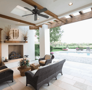 a patio with wicker furniture and a fireplace