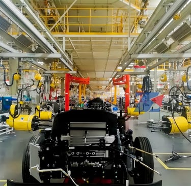 Four robotic five-axis wheel nut runners installing tires on a vehicle