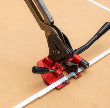 Manual strapping machine and white plastic strap used for sealing and packing