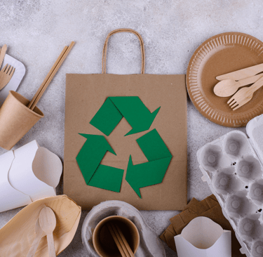 custom packing materials and a paper bag with a recycling bin of cardboard boxes and a recycling bin