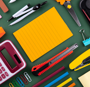 a desk with a lot of office supplies and a calculator