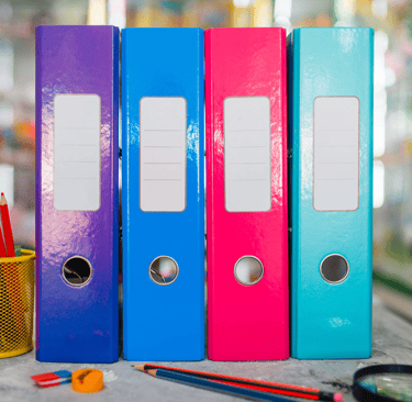 a row of three binder binders with pencils and pencils