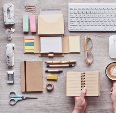 a person holding a cup of coffee and a notebook