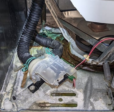 top load washer front panel is removed, drain pump i visible