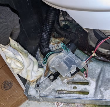 front panel off washing machine. A technician holding a sock