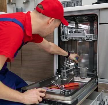 a person red hat repairing a dishwasher 