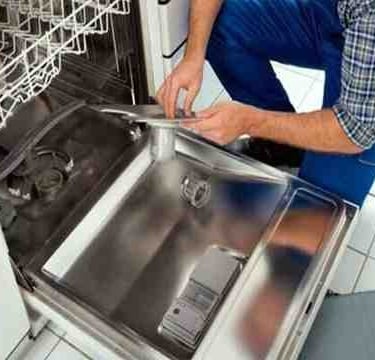 a technician cleaning the filter of a dishwasher