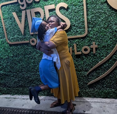 two women hugging each other in front of a sign that says good vibes