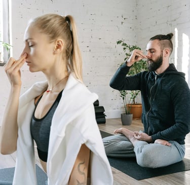 a man and woman sitting on a yoga mat