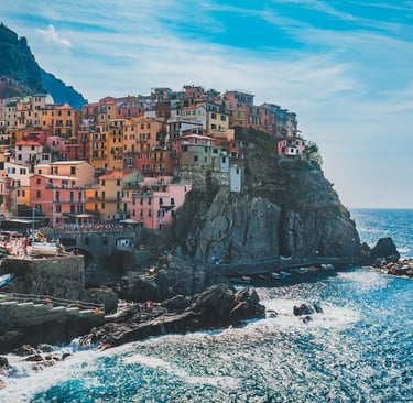 a view of a town with a view of the ocean, slow travel Italy