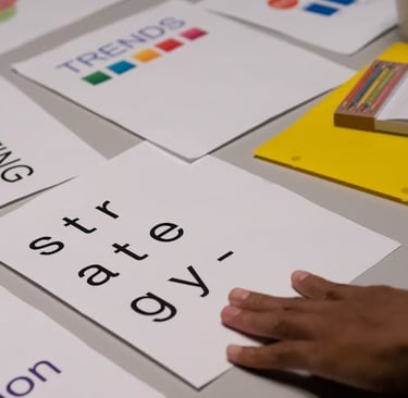 Hand touching marketing strategy and business trends documents during a corporate planning meeting.