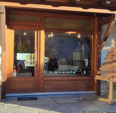 ingresso e vetrina del negozio di Sampeyre della Mieleria Garnero, con insegna e ape di legno