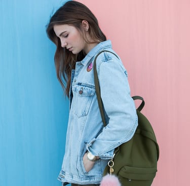 étudiante de profil, avec sac de cours, la tête baissée,