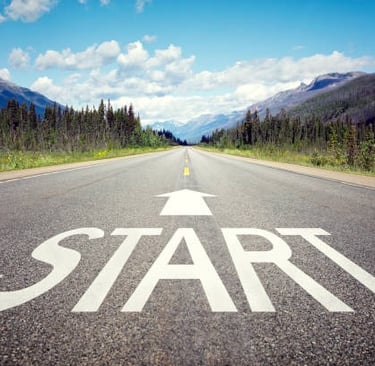 Start here written on roadway with beautiful background