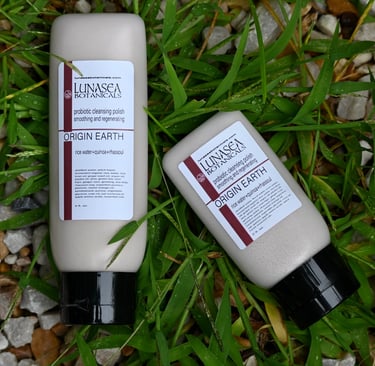 lunasea botanicals probiotic scrub 2 bottles laying in green grass