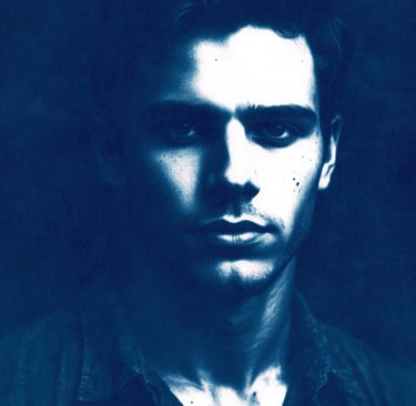 Close-up portrait of a young man with a serious expression, defined features, and short wavy dark ha
